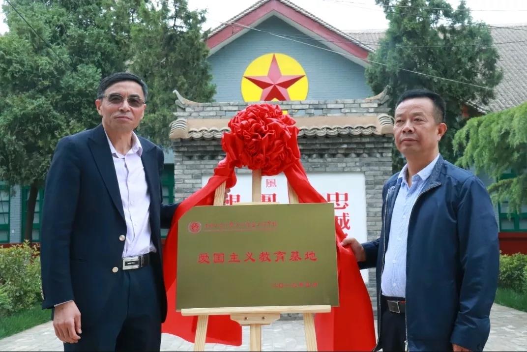 与西安市高陵区文体广电旅游局副局长朱永贤为"爱国主义教育基地"揭牌